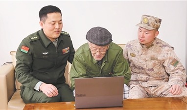 图①:路晨(中)在佟指导员(左)陪伴下与官兵视频连线。