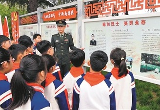 “申亮亮班”第3任班長湯宏華正在給前來烈士陵園祭掃的溫縣城內小學的學生們講述“人民英雄”申亮亮的事跡。本報記者  汪  飛攝