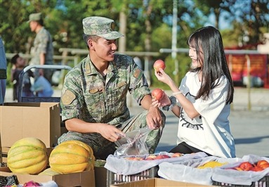 日前，新疆军区某团组织开展“文化集市”活动。图为二级上士范常杰（左）同爱人崖洋春一起挑选蔬果，共享团圆时刻。周裕斌摄