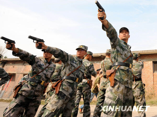 10月20日,参加手枪射击考试的空降兵某部分队军官在考前试枪.