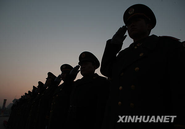 2009年11月23日,参加升旗仪式的武警官兵在天安门广场向国旗敬礼.
