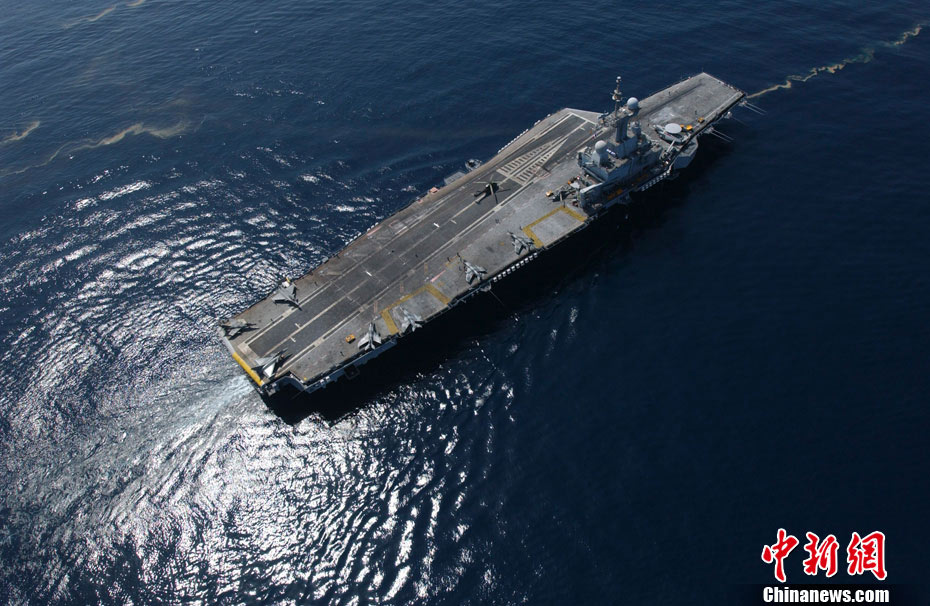 图为3月20日,法国“戴高乐”号核动力航空母舰从法国土伦海军基地启程,参与对利比亚的军事打击行动。