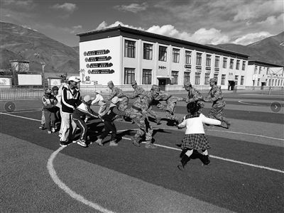 卡达边防连的“兵老师”在卡达乡小学与孩子们玩游戏。李国涛、李学文摄