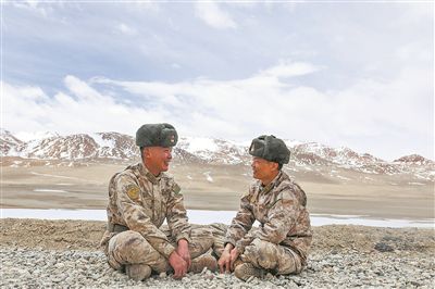 新疆军区某边防团天文点边防营教导员刘小赣（右）与战友谈心。