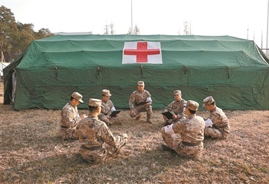 空军某场站医院医护人员参加实战化卫勤训练后进行复盘讨论。包迪 摄