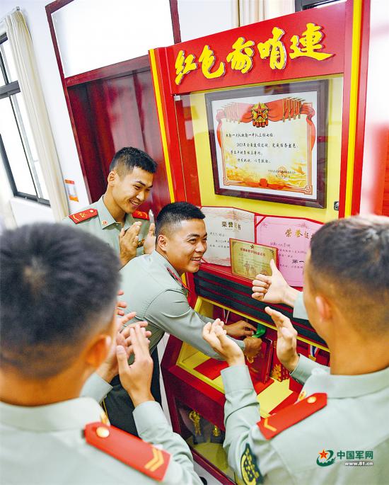 中队战士将比武中获得的奖牌放入荣誉柜。